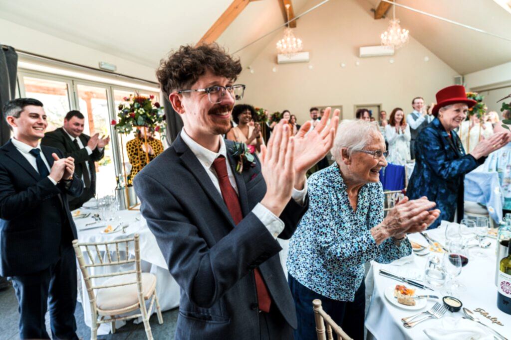 People clapping at a wedding reception.