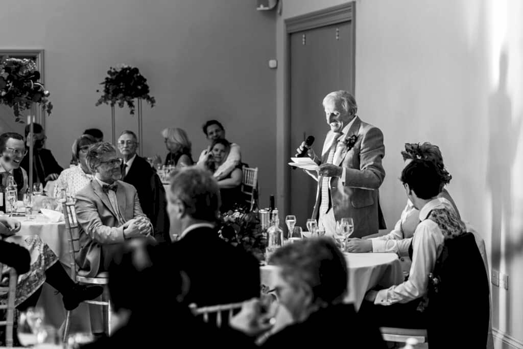 Elderly man giving speech at formal event.