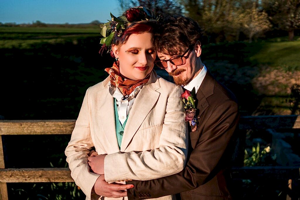 Couple embracing outdoors in formal attire.
