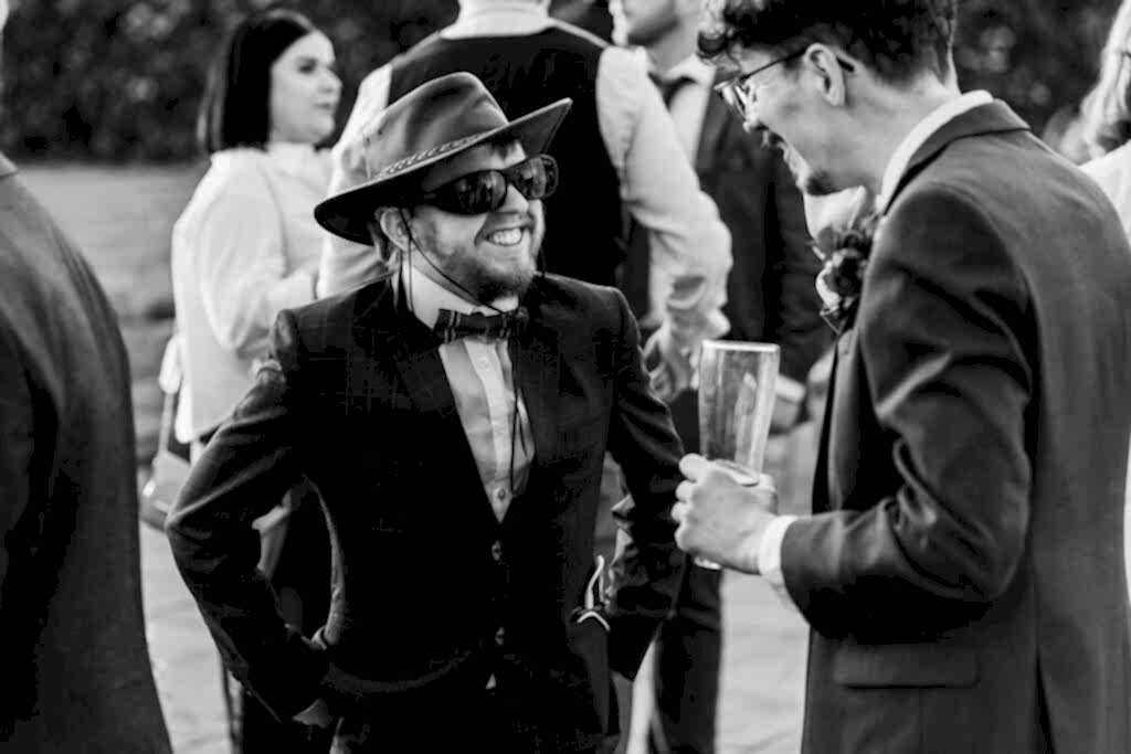 Men in suits laughing at outdoor event