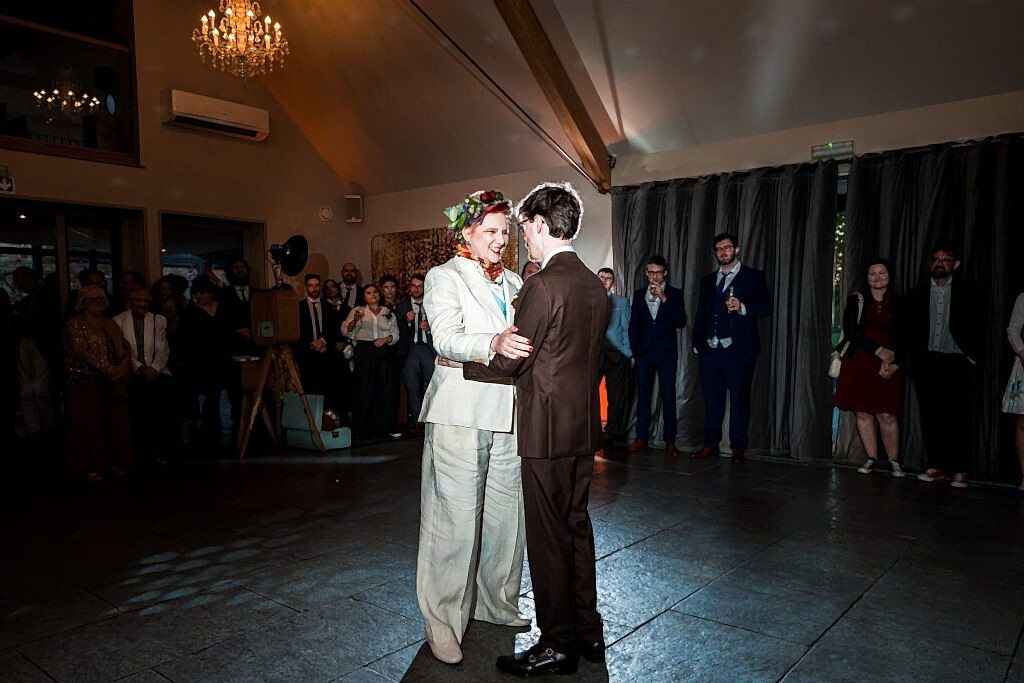 Couple dancing at wedding reception with guests watching.