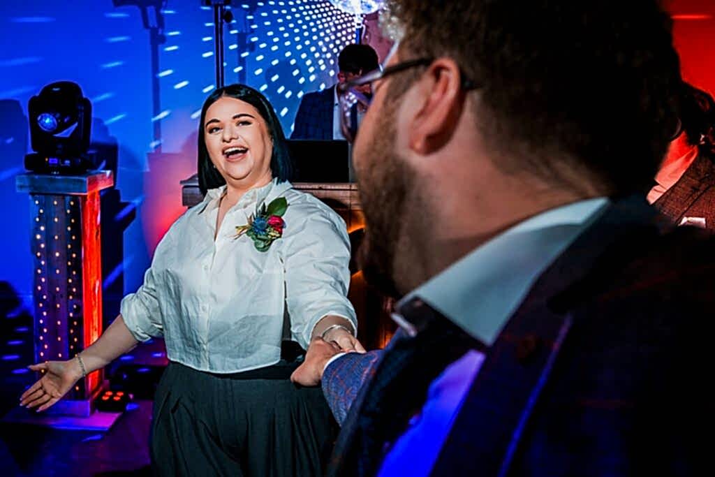 People dancing at a vibrant party with lighting.