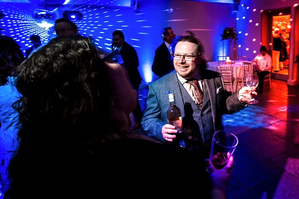 Man celebrating with wine at party.