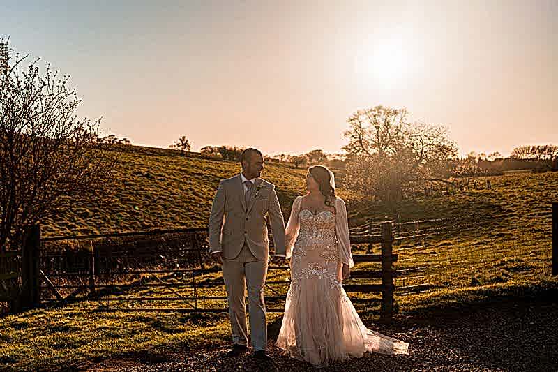 Couple walking hand in hand at sunset.