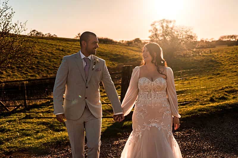 Couple walking hand in hand at sunset.